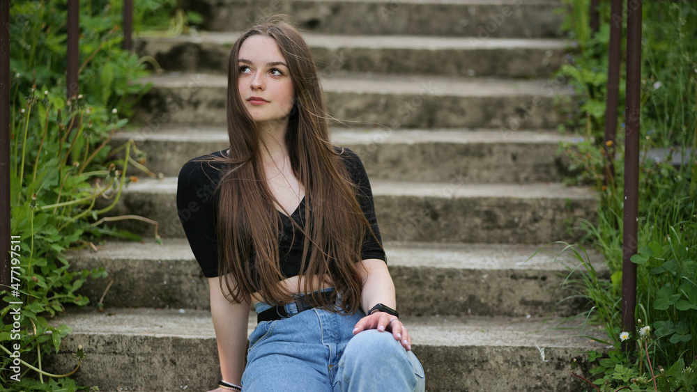 Nice girl posing while sitting on the stairs.