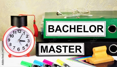 Bachelor's and Master's degrees. The inscription on the folders on the background of the planning clock and the student hat.