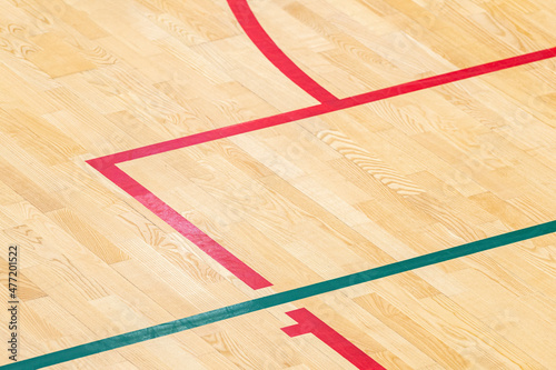 Wooden floor basketball, badminton, futsal, handball, volleyball, football, soccer court. Wooden floor of sports hall with marking red and green lines on wooden floor indoor, gym court