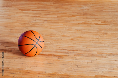 Basketball on hardwood court floor with natural lighting. Workout online concept. Horizontal sport theme poster, greeting cards, headers, website and app