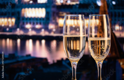 Photography two champagne glasses against fireworks in the city New Year's eve celebrations