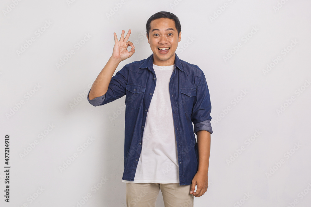 Portrait of happy asian young man showing okay gesture isolated on white background
Portrait of happy asian young man showing okay gesture isolated on white background