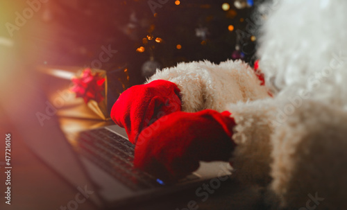 Santa claus is typing a letter on the computer.