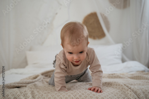 Cute toddler baby crawling on bad at home