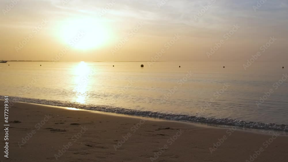 Calm sea shore with crushing waves on sandy beach at sunrise Calm sea shore with crushing waves on sandy beach at sunrise