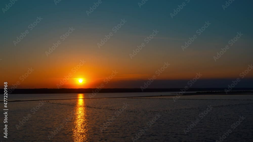 Panoramic seashore view with dramatic golden sunset. Calm beach in background. Panoramic seashore view with dramatic golden sunset. Calm beach in background.