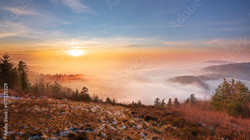 The last warm rays of the sun meet the cool fog over the Murg valley in the Black Forest