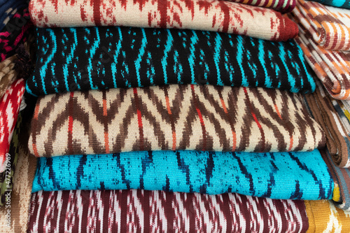 Scarves or Macanas at the market, traditional handcraft and design for Gualaceo canton, Azuay province, made by using technique called Ikat, colorful fabrics background. Cuenca, Ecuador photo