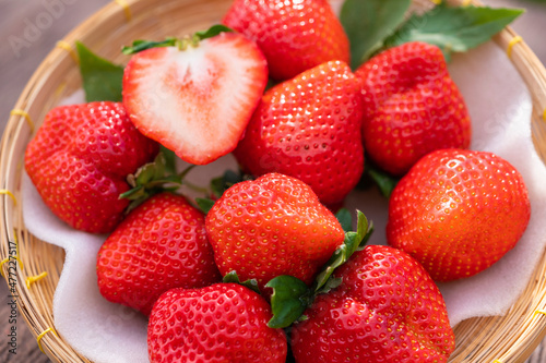 Fototapeta Naklejka Na Ścianę i Meble -  Fresh organic juicy strawberries in a wicker tray on a brown shabby wooden table
