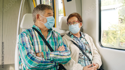 Spanish retired couple with medical mask traveling on a train. 