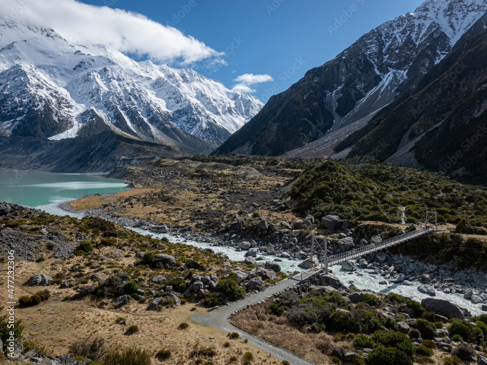 Glacial Lake on the Hooker Valley Track with Bridge and snowy mountain range to Mt Cook New Zealand