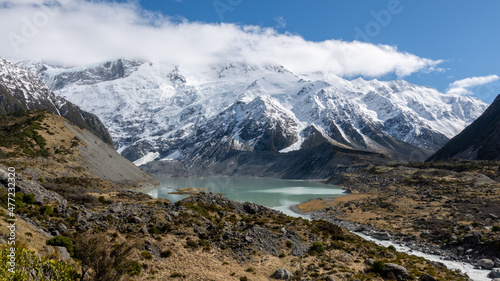 Glacial Lake on the Hooker Valley Track in summer with snowy mountain range to Mt Cook New Zealand