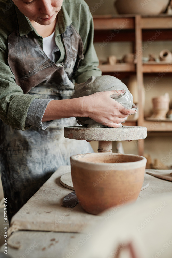Close-up of worker making form of future vase from piece of clay working in ceramic workshop Close-up of worker making form of future vase from piece of clay working in ceramic workshop