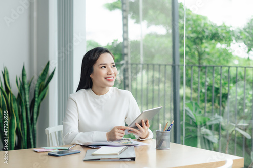 Woman using digital tablet while sitting at home