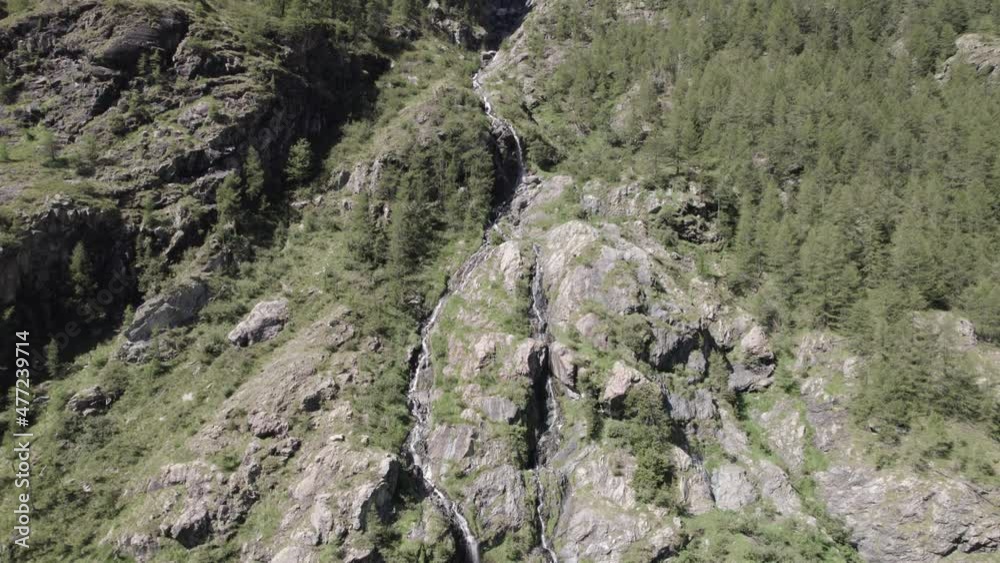 video of crane plane or ascent with bird's eye view at the end with drone flying over a waterfall in the italian alps