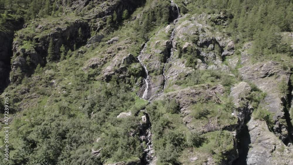 video of crane plane or ascent with drone flying over a waterfall in the italian alps