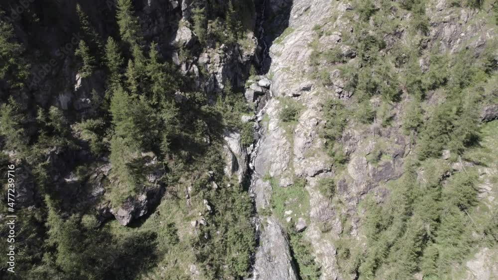 plane video with reverse description with drone flying over a waterfall in the italian alps