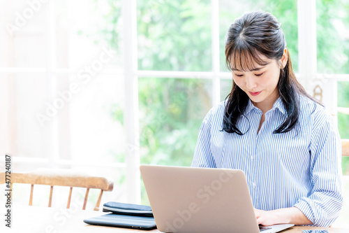 Free Download Beautiful Asian woman working on a computer with her head down, copy space available. - GFXLoad