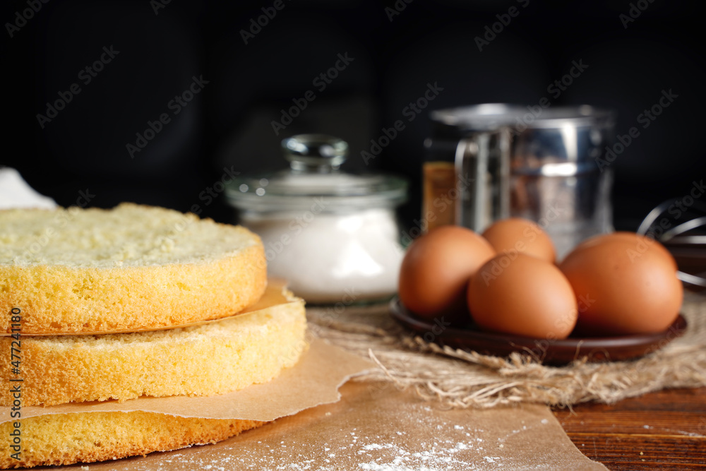 Fototapeta premium Cutting the biscuit into layers. Slicing sponge cake at home in the kitchen.