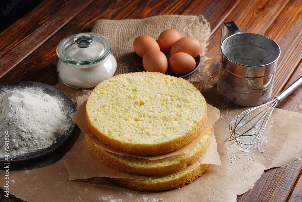 Cutting the biscuit into layers. Slicing sponge cake at home in the kitchen. Cutting the biscuit into layers. Slicing sponge cake at home in the kitchen.