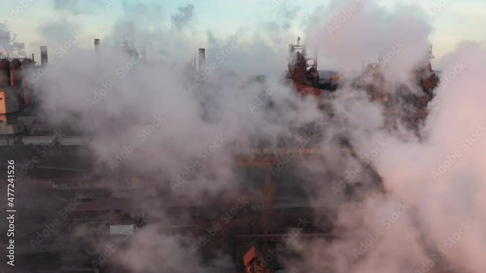 Drone around toxic enterprise chimneys tubing against the sky background release smoke. Factory pollutes environment. Aerial view Drone around toxic enterprise chimneys tubing against the sky background release smoke. Factory pollutes environment. Aerial view
