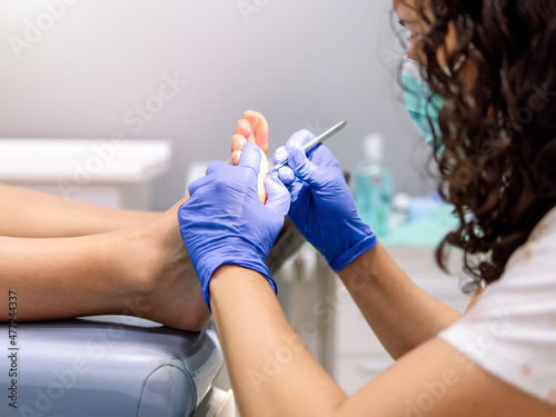 Female podiatrist doing chiropody in her podiatry clinic. Selective focus photo