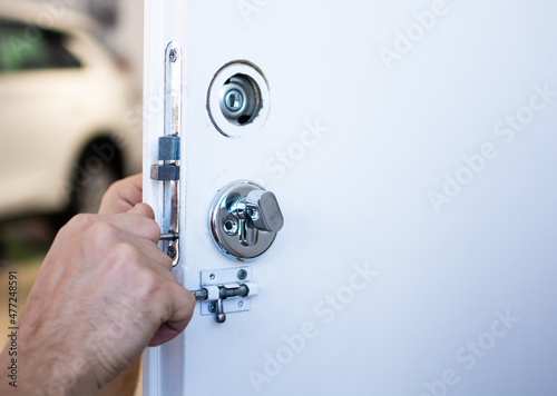 Tablou pe pânză Closeup of a locksmith installing or repairing a new deadbolt lock on a house exterior door