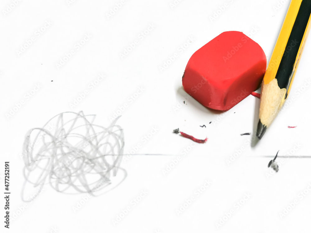 Close yup photo of pencil and eraser deleting a crooked line from a straight line.