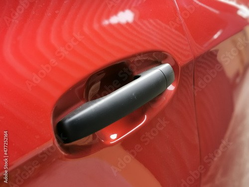 Close up photo of red car door handle.