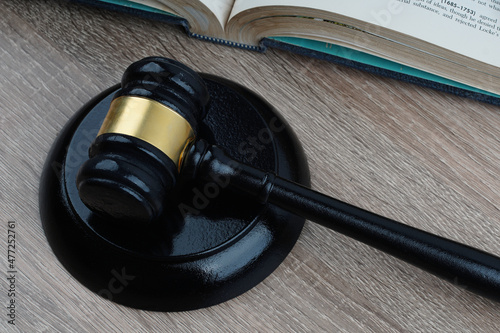 gavel and sound block on a wooden table with a book as background 