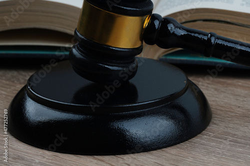 gavel and sound block on a wooden table with a book as background 