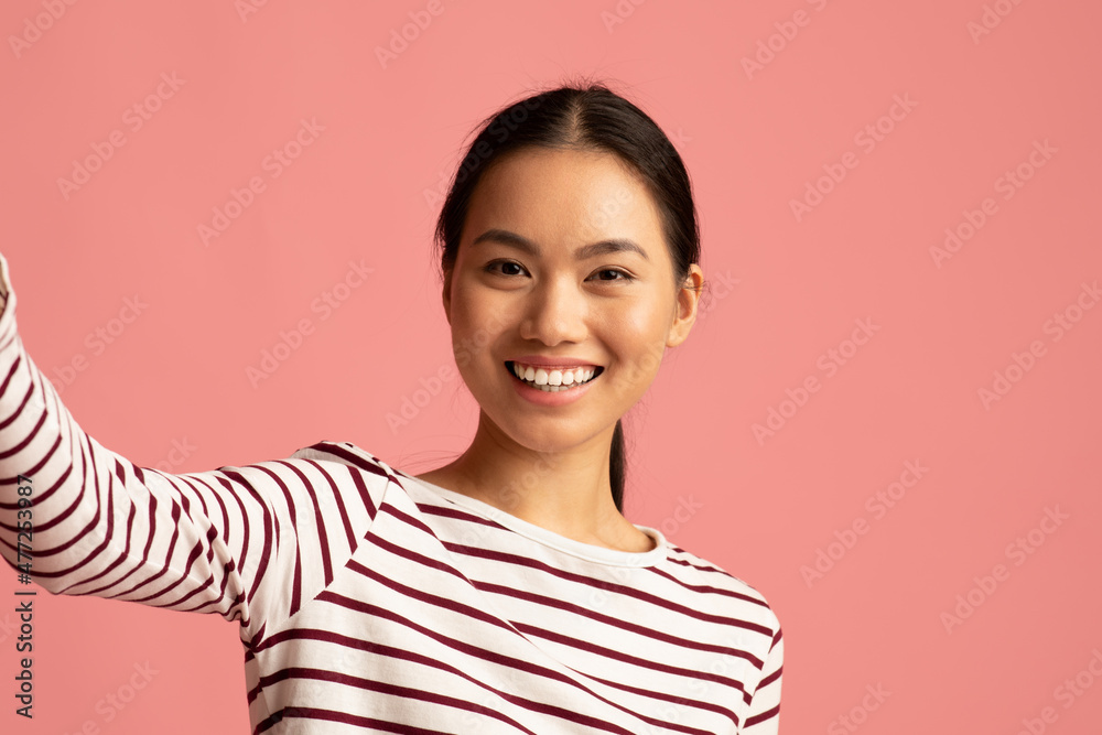Happy Young Asian Woman Taking Selfie While Posing Over Pink Studio Background Happy Young Asian Woman Taking Selfie While Posing Over Pink Studio Background