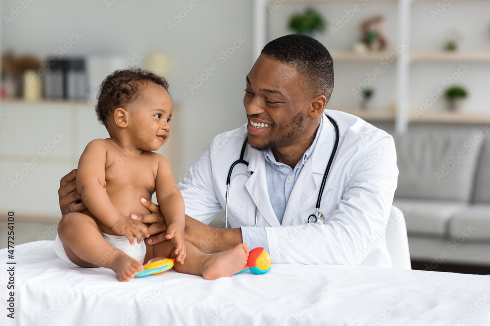 Portrait Of Smiling Black Doctor Making Check Up For Infant Baby Boy Portrait Of Smiling Black Doctor Making Check Up For Infant Baby Boy
