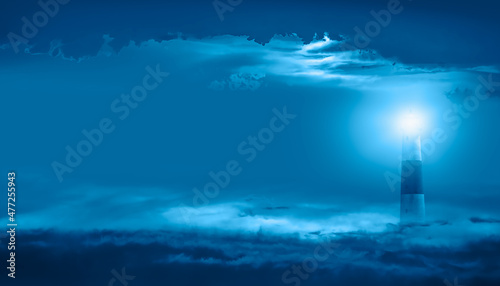 A lighthouse in the clouds at night