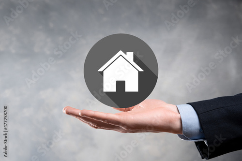 Real estate concept  businessman holding a house icon.House on Hand.Property insurance and security concept. Protecting gesture of man and symbol of house.flat icons with long shadows