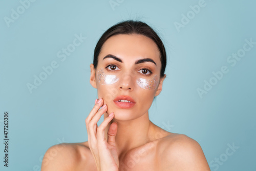 Close beauty portrait of a topless woman with perfect skin and natural make-up  shiny patches under the eyes  to moisturize the skin and relieve puffiness of the face