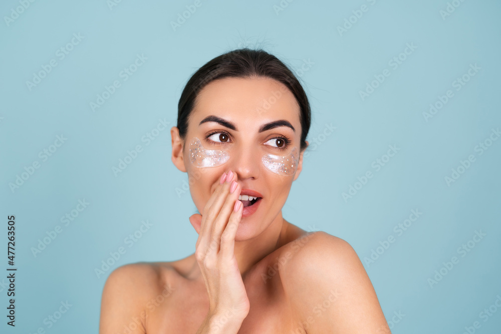 Close beauty portrait of a topless woman with perfect skin and natural make-up, shiny patches under the eyes, to moisturize the skin and relieve puffiness of the face Close beauty portrait of a topless woman with perfect skin and natural make-up, shiny patches under the eyes, to moisturize the skin and relieve puffiness of the face