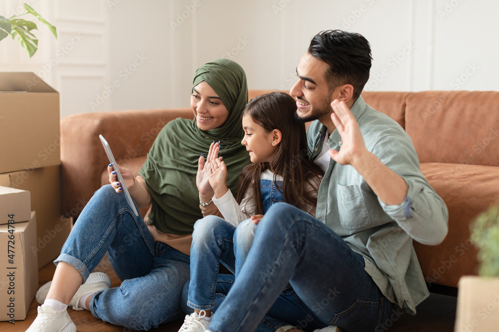 Arab family having videocall using tablet waving hands