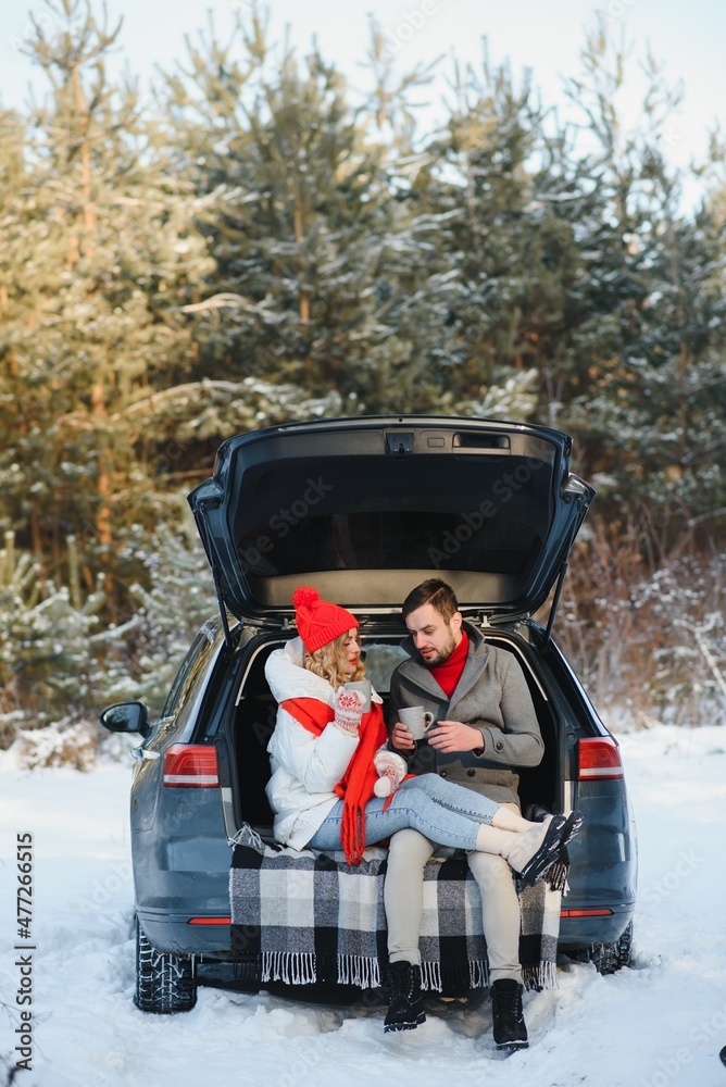 Cute Couple Having Winter Forest Picnic Drinking Tea from Tea Take Away Cup. Nature Picnic. Love Story Date at Car.