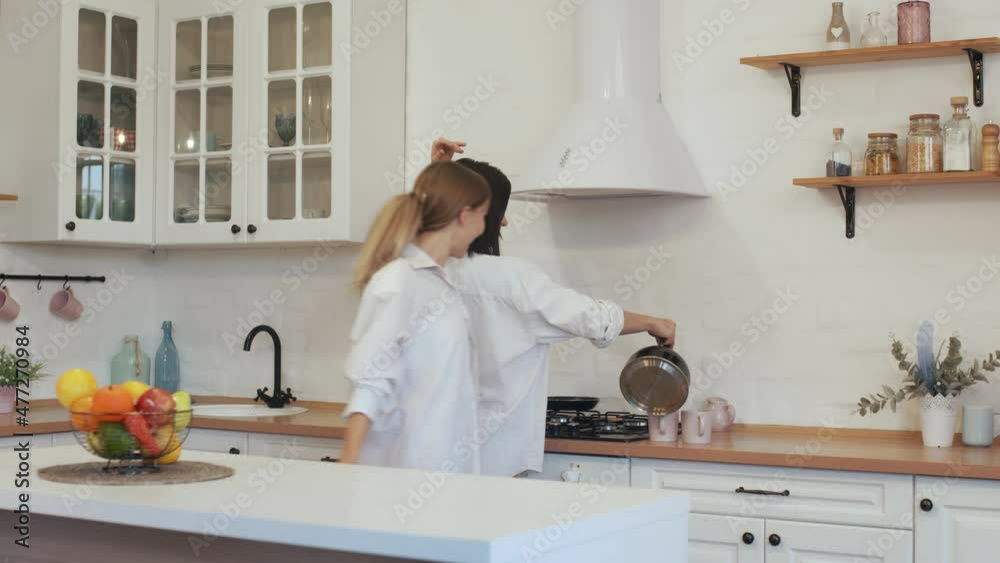 Happy homosexual couple making coffee and dancing talking at the table in the kitchen. Two young Europeans cook breakfast together and dance with smiles Lesbians cook
Happy homosexual couple making coffee and dancing talking at the table in the kitchen. Two young Europeans cook breakfast together and dance with smiles Lesbians cook