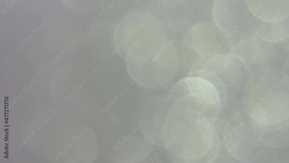 Spinning grey and silver bokeh spots background Spinning grey and silver bokeh spots background