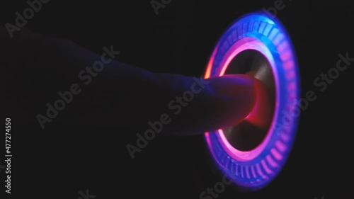 A person's finger presses the computer start button. Illuminating button to turn on the computer on the system unit. 4k macro loop video.