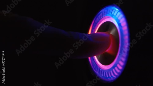 A person's finger presses the computer start button. Illuminating button to turn on the computer on the system unit. 4k macro loop video.