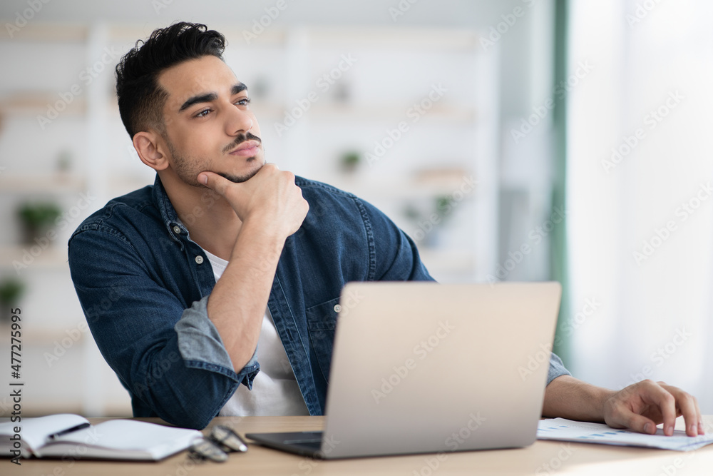 Thoughtful man sitting in office and looking at copy space Thoughtful man sitting in office and looking at copy space