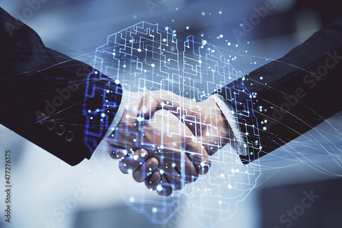 Double exposure of brain hologram and handshake of two men. Partnership in IT industry concept.