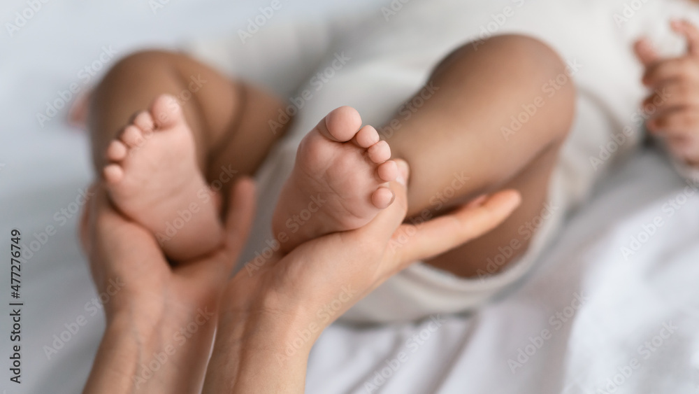 Closeup of woman holding feet of cute little African American baby Closeup of woman holding feet of cute little African American baby