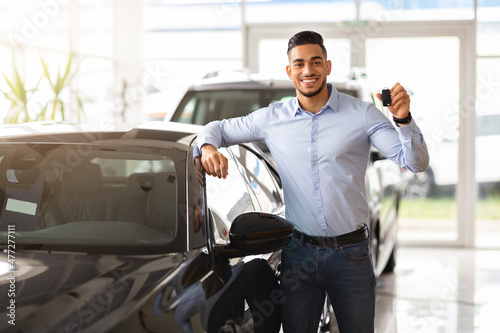 Handsome arab man customer holding key from auto, buying car © Prostock-studio