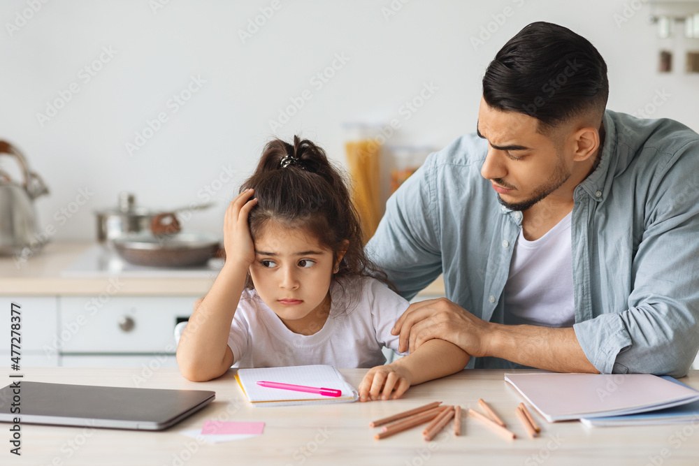 Young arab man single father comforting his upset daughter Young arab man single father comforting his upset daughter