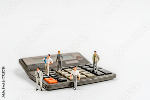 Miniature figures of businessmen stand on wooden accounts to calculate profits. The concept of business and making money