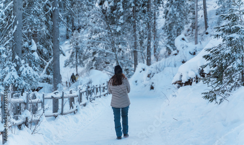 Woman taking a walk in the middle of a snow-filled forest